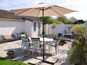 a table and chairs under an umbrella on a patio at The Chicken Shed in Ruckinge