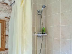 y baño con ducha con cabezal de ducha. en Craik Forestry Cottage, en Teviothead