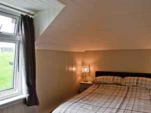 a bedroom with a bed and a window at Cuillin View House - Uk12528 in Arisaig