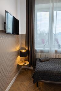 een slaapkamer met een bed en een televisie aan de muur bij ClickTheFlat Wilcza 35 City Center Apart Rooms in Warschau