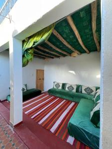 a room with two green beds on a carpet at Riad Mama Toutou in Marrakech