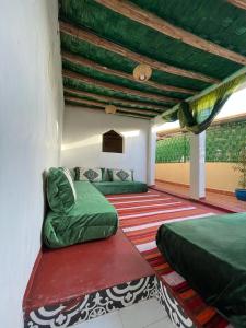 Un dormitorio con dos camas y un techo verde. en Riad Mama Toutou, en Marrakech