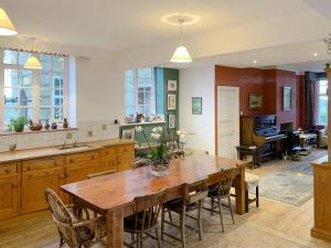 a large kitchen with a wooden table and chairs at Castle Hill House in Sidbury