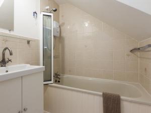 een badkamer met een wastafel en een bad bij College View 2 Upper in Kingswear