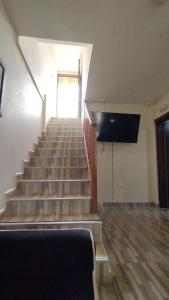 a room with stairs with a television and a stair case at Canto del rio in Jardin