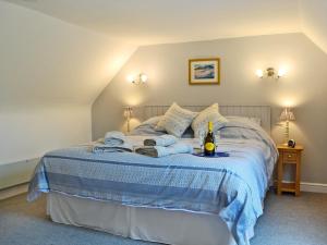 a bedroom with a bed with towels and a bottle of wine at Bridge Cottage in New Channelkirk