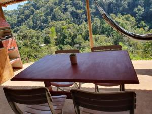 uma mesa e cadeiras de madeira com vista para as montanhas em Casa Container na Serra da Bocaina em São José do Barreiro
