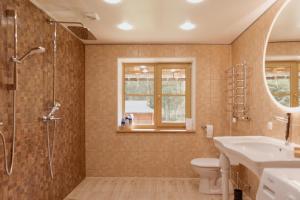 a bathroom with a sink and a shower and a toilet at Viesu nams “Kalna Raskumi” in Vecpiebalga +45 photos