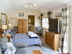 a living room with a bed and a flat screen tv at Courtyard Barn - Uk11927 in Lessingham