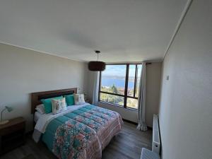 a bedroom with a bed and a large window at TuArriendoCL-MPHB402 Dpto con vista al Lago 2D2B hasta 5Pax in Puerto Varas