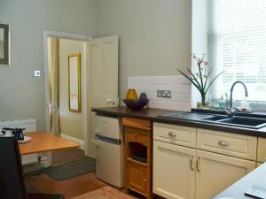 cocina con fregadero y encimera en Porters Lodge en Axminster