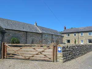 a wooden gate in front of a stone wall at Grangemoor Barn in Rothley