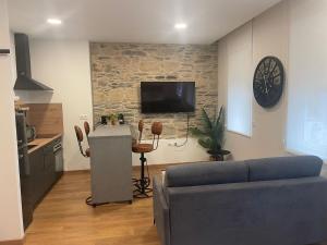 a living room with a couch and a tv on a wall at Hostal Zahara in Ferrol