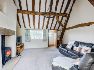 een woonkamer met een bank en een open haard bij The Restored Cottage in Eccleston