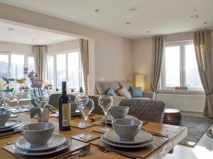 a dining room table with a bottle of wine and glasses at Lily Lodge - Uk31958 in Dibaig