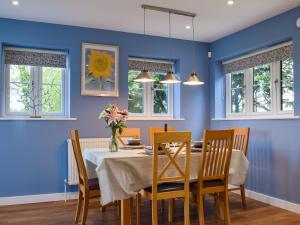 ein Esszimmer mit blauen Wänden und einem Tisch mit Stühlen in der Unterkunft Southfield in Steventon