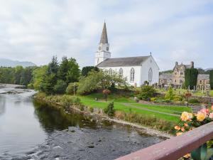 a church and a river in front of a church at The Granary - Uk34899 in Dunira