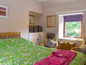 a bedroom with a bed with a pink blanket on it at Ashfield in Paxton