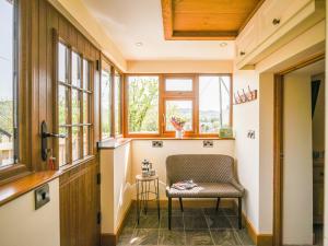 a small room with a chair and windows at Pentre Cottage in Meifod