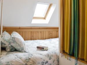 a bedroom with a bed with a book on it at Larch Cottage in Balnald