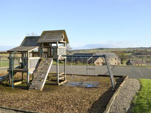 a playground with a slide and a play structure at The Farmhouse in Llanarth