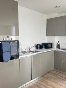 a white kitchen with white cabinets and appliances at Next to London City airport Apartments in Woolwich