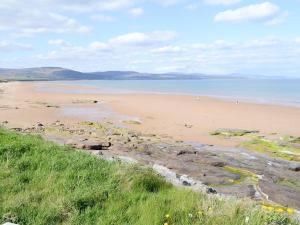 a sandy beach with people walking on the beach at Oyster Catcher in Embo