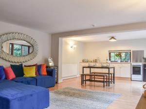 a living room with a blue couch and a table at The Barn in Chipperfield