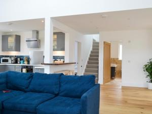 a blue couch in a living room with a kitchen at Barrach in Ardfern