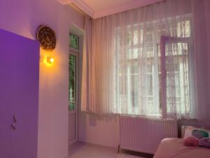Schlafzimmer mit einem Bett und einem Fenster mit rosa Vorhängen in der Unterkunft A Nice Place in the City Centre in Meram