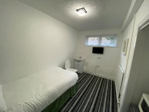 a small bedroom with a bed and a window at Aaran Central Guesthouse in Aberdeen