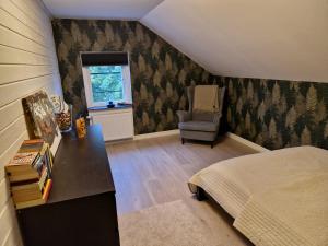 1 dormitorio con cama, escritorio y silla en Eldaren, en Tranås