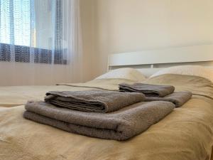 una pila de toallas sentadas encima de una cama en Charming Private Rooms in a Great Location, en Budapest