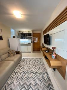 a living room with a couch and a television at Israel Flat Tambaú in João Pessoa