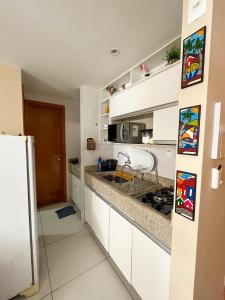 a kitchen with white cabinets and a counter top at Israel Flat Tambaú in João Pessoa