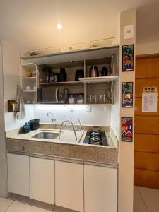 a kitchen with a sink and a stove at Israel Flat Tambaú in João Pessoa