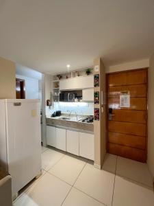 a kitchen with a refrigerator and a counter top at Israel Flat Tambaú in João Pessoa