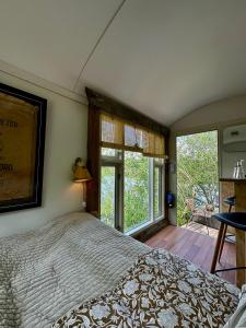 ein Schlafzimmer mit einem Bett und einem großen Fenster in der Unterkunft Krusmølle Glamping in Aabenraa