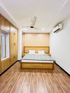 1 dormitorio con 1 cama y ventilador de techo en Noors B&B en Islamabad