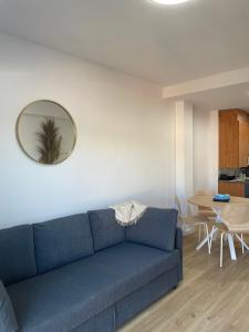 a blue couch in a living room with a mirror at Acogedor apartamento Vallparadís con parking in Terrassa