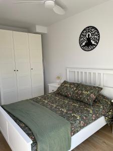 a bedroom with a bed and a clock on the wall at Acogedor apartamento Vallparadís con parking in Terrassa