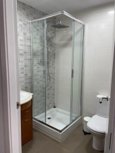 a bathroom with a glass shower and a toilet at Acogedor apartamento Vallparadís con parking in Terrassa