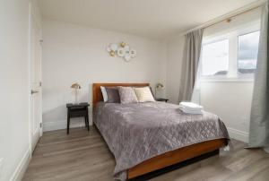 ein weißes Schlafzimmer mit einem Bett und einem Fenster in der Unterkunft Stylish House W a Media Room Near Downtown Picton in Picton