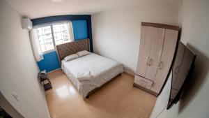 een kleine slaapkamer met een bed en een raam bij Blu Hostel in Panama-Stad