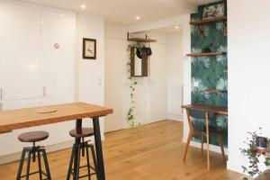 a dining room with a table and two stools at 47 m2 bright nest near Paris in Aubervilliers