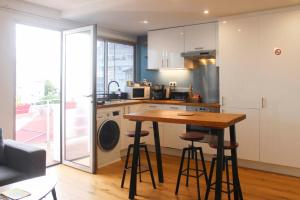 a kitchen with a table and stools in a room at 47 m2 bright nest near Paris in Aubervilliers