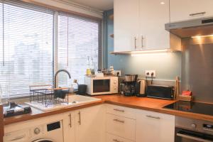 a kitchen with a counter top with a microwave at 47 m2 bright nest near Paris in Aubervilliers