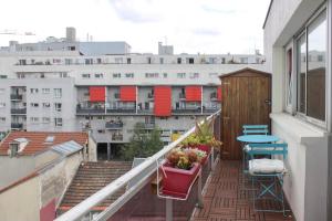 a balcony with a table and chairs and buildings at 47 m2 bright nest near Paris in Aubervilliers