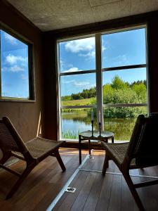 a room with two chairs and a table and a large window at Krusmølle Glamping in Aabenraa