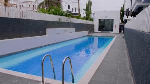 a swimming pool with blue water in a building at Favourite Luxury 3 Bedroom Apartment in Ikeja